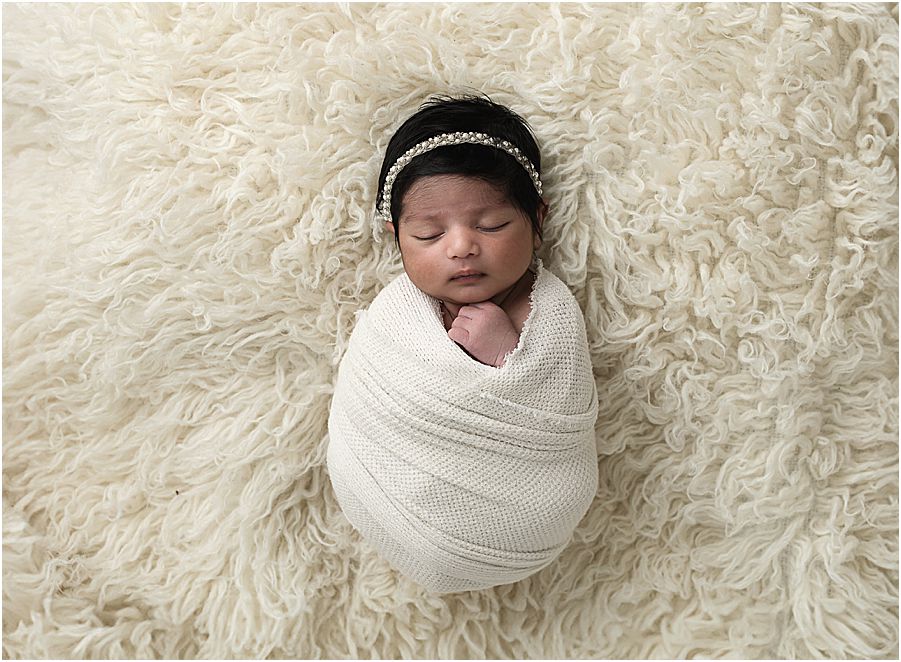 baby girl wrapped in cream swaddle