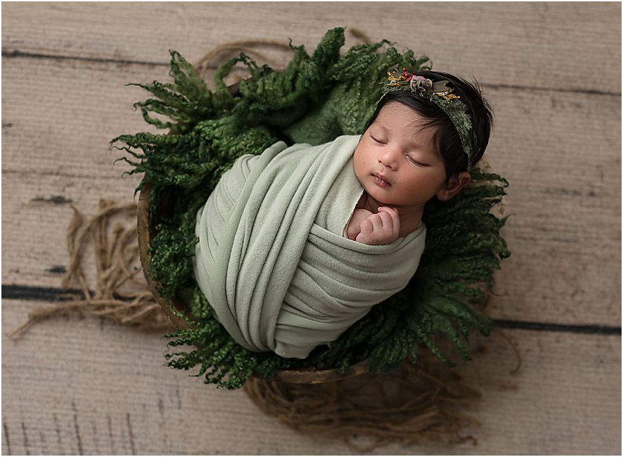 Newborn baby girl swaddle in sage green