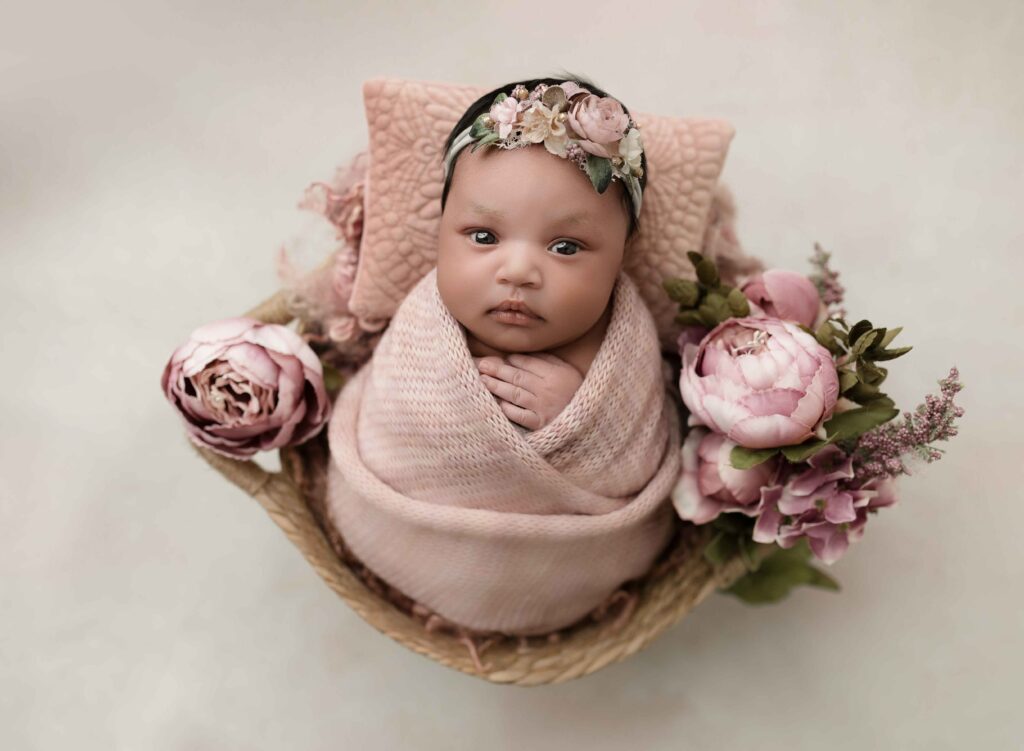 baby girl wrapped in pink looking straight at camera