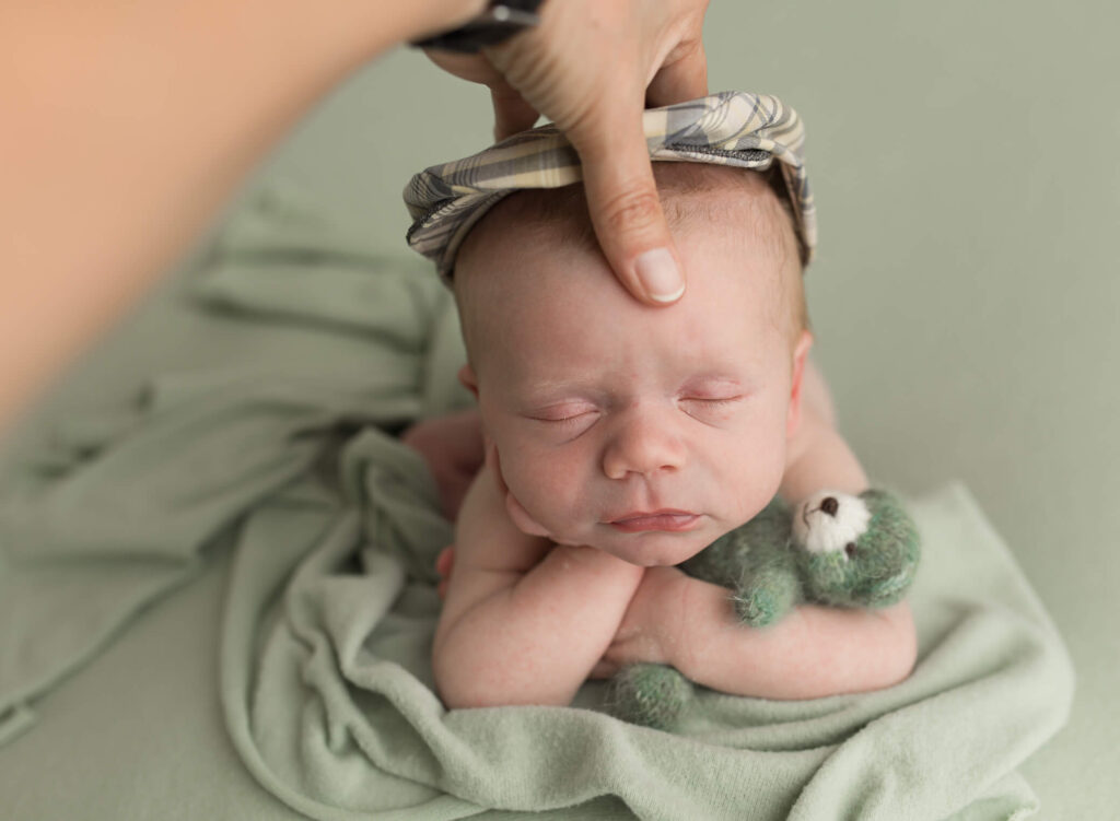 baby being supported during froggy pose- atlanta newborn photographer